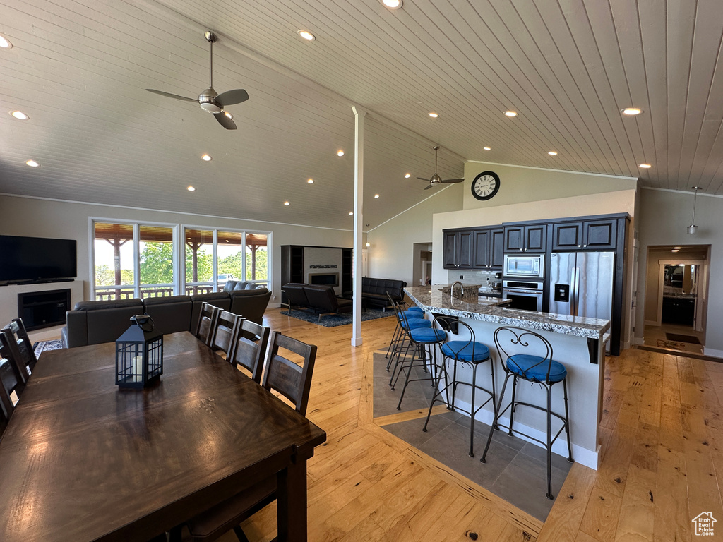 Dining area with a ceiling fan, wooden ceiling, recessed lighting, light wood-style flooring, and a fireplace