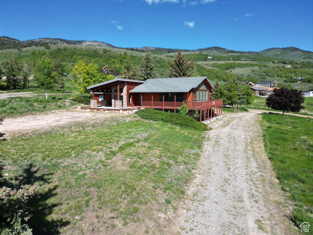 View of front of home with driveway and a deck with mountain view