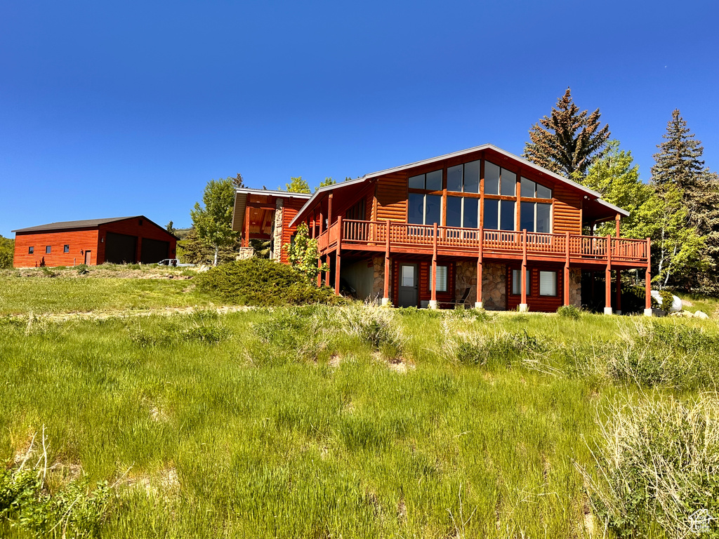 Rear view of property with a garage and a deck