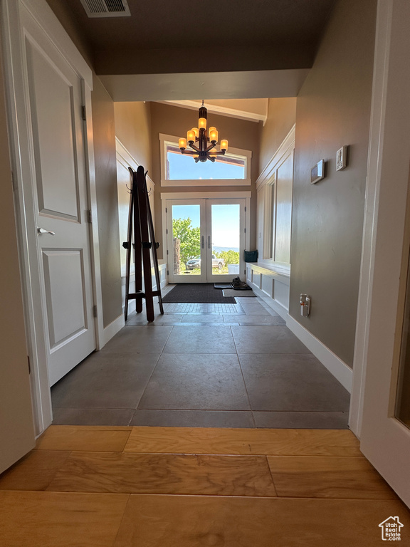 Entryway featuring a chandelier, french doors, and baseboards
