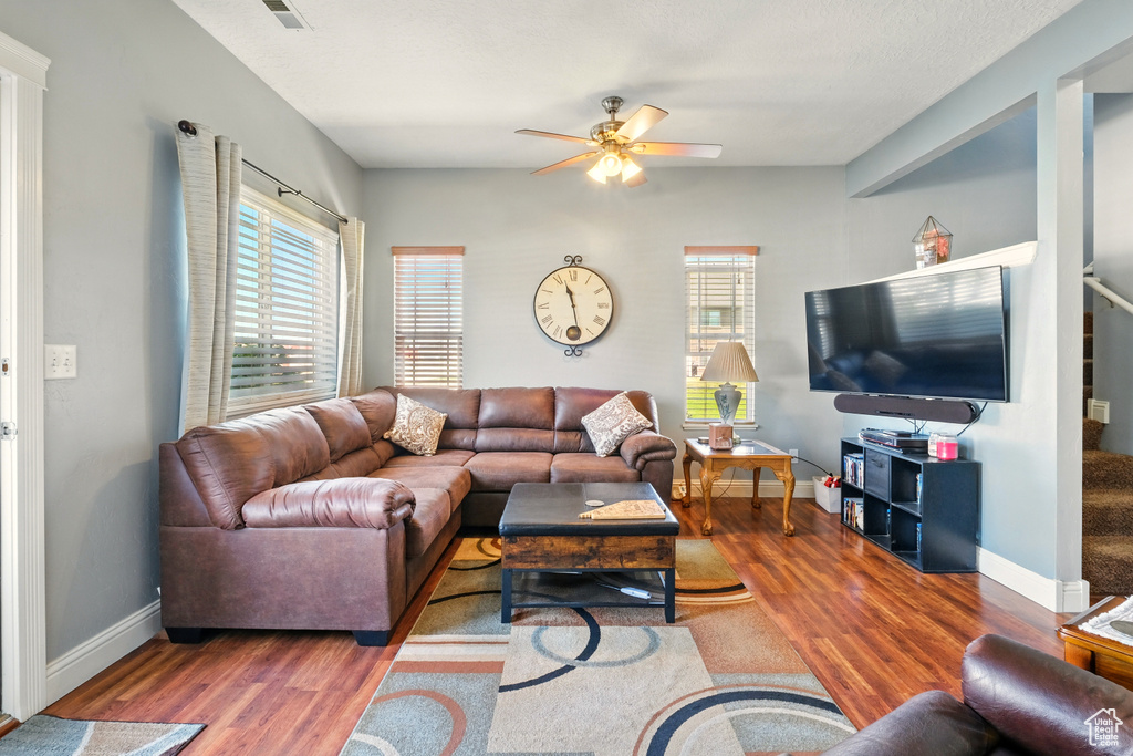 Living area featuring wood finished floors, ceiling fan, and baseboards