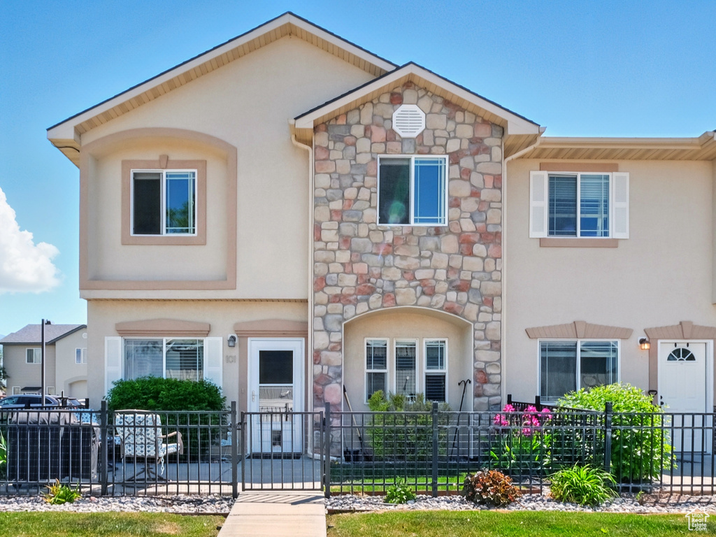 Townhome / multi-family property with stucco siding and stone siding
