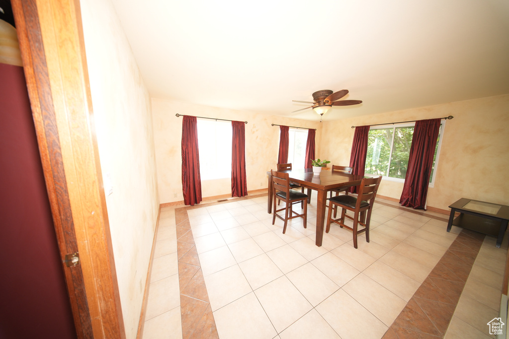 Dining area featuring ceiling fan, light tile patterned floors, and baseboards