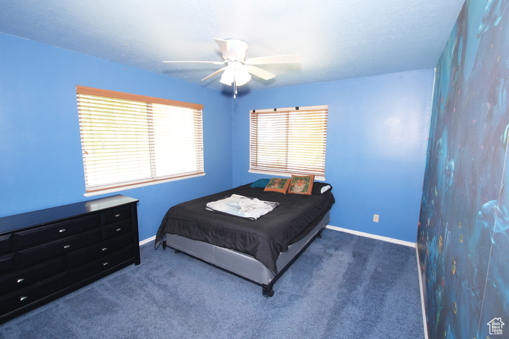 Bedroom featuring baseboards, carpet flooring, and a ceiling fan