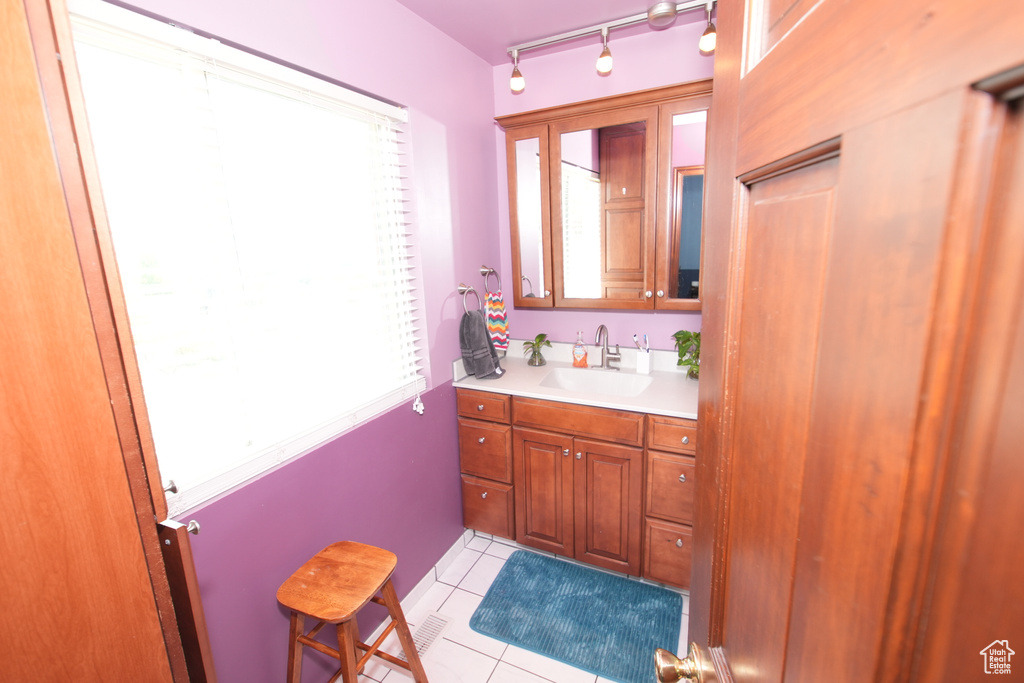 Bathroom featuring plenty of natural light, vanity, and tile patterned flooring