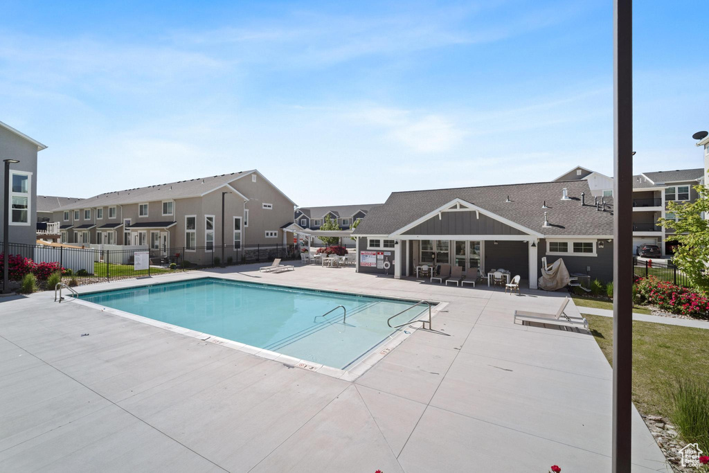 Community pool featuring a patio area and a residential view