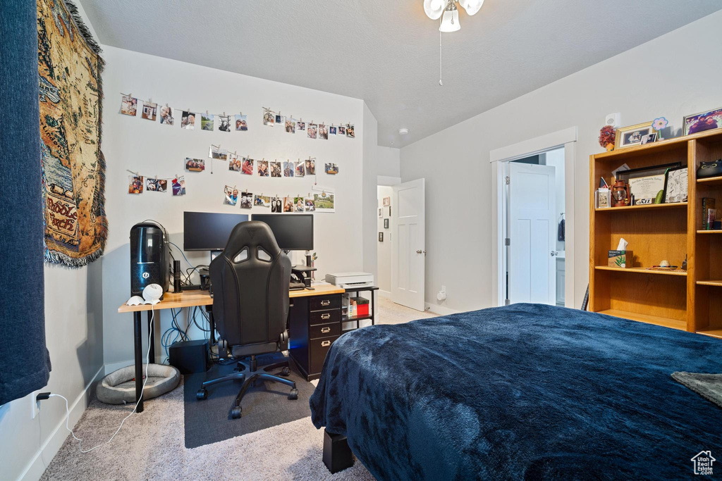 Carpeted bedroom featuring baseboards and a desk