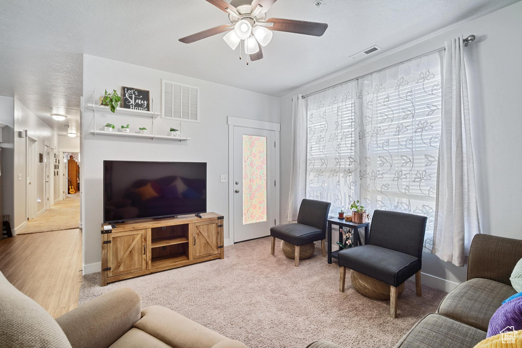 Living room featuring a ceiling fan and carpet floors