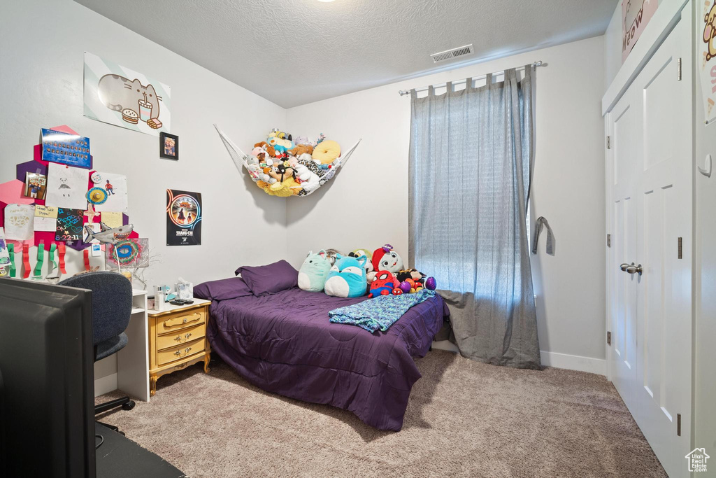 Carpeted bedroom with a textured ceiling