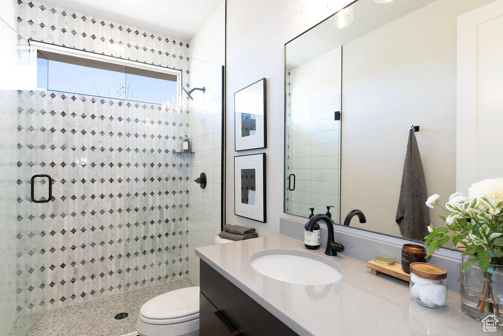 Bathroom with a shower stall, vanity, and toilet