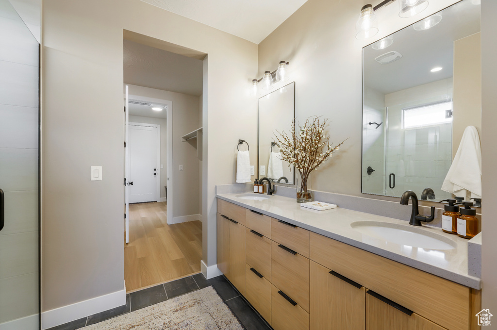 Full bath featuring double vanity and baseboards