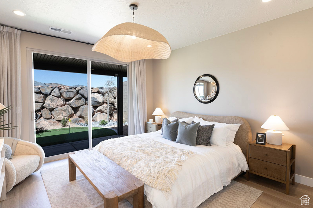Bedroom with access to outside, light wood finished floors, baseboards, and recessed lighting