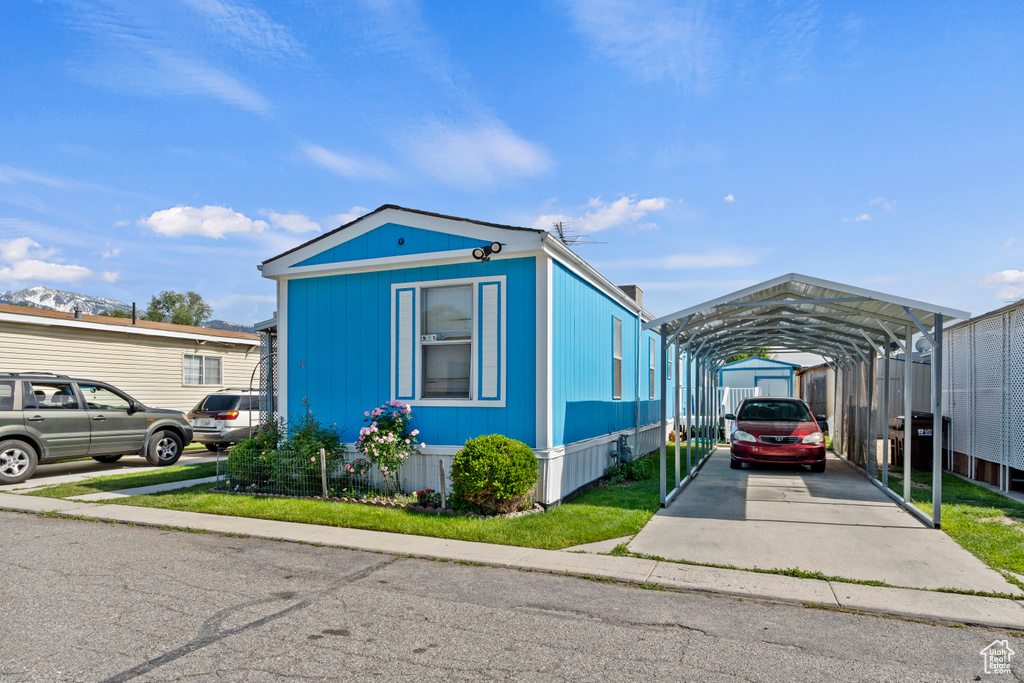 View of front of home with a detached carport and driveway