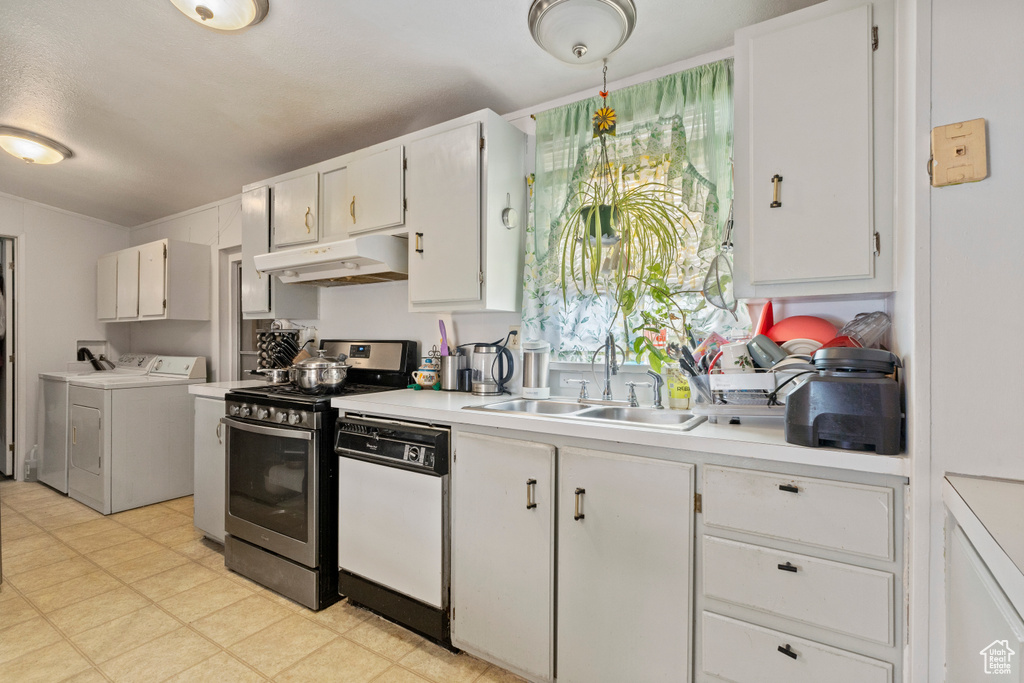 Kitchen with under cabinet range hood, stainless steel range, washing machine and clothes dryer, white dishwasher, and a sink