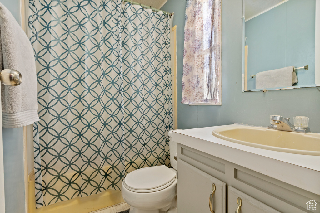 Full bath featuring vanity, toilet, and a shower with shower curtain