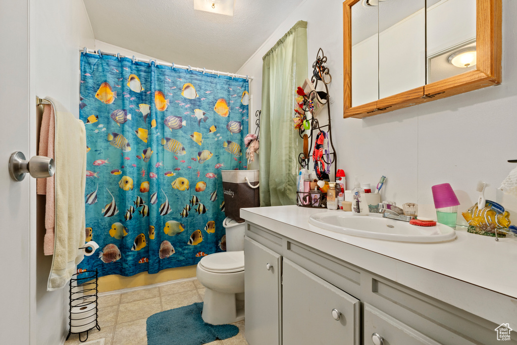 Bathroom with vanity, toilet, and tile patterned flooring