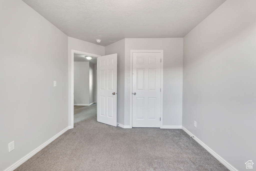 Unfurnished bedroom with carpet floors and baseboards
