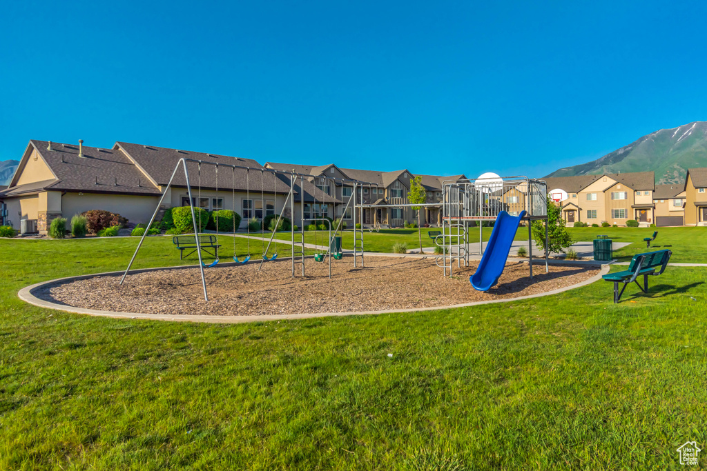 Community play area with a residential view, a yard, and a mountain view