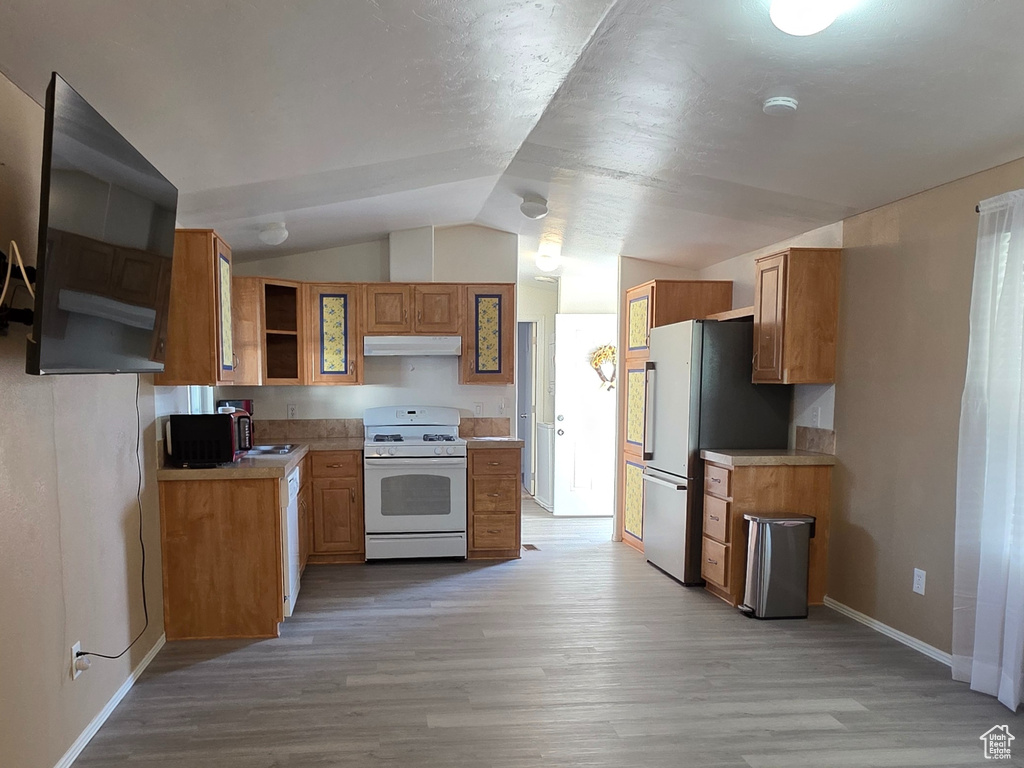 Unfurnished living room with lofted ceiling, baseboards, dark wood-style flooring, and a sink