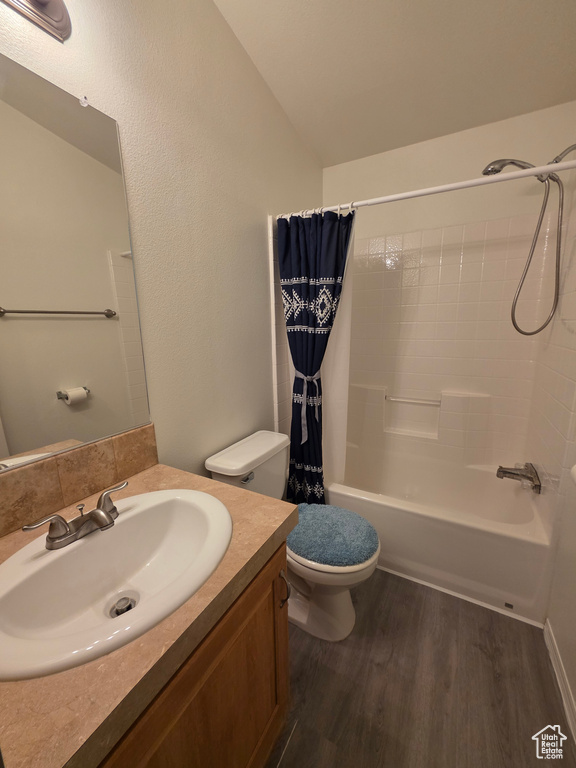 Full bath with wood finished floors, vanity, toilet, and shower / bath combo with shower curtain