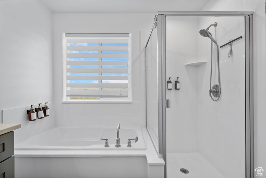Full bath with a stall shower, a bath, and vanity