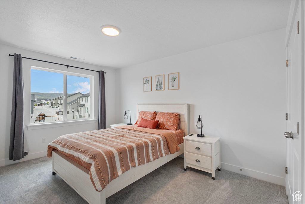 Bedroom with light carpet and baseboards