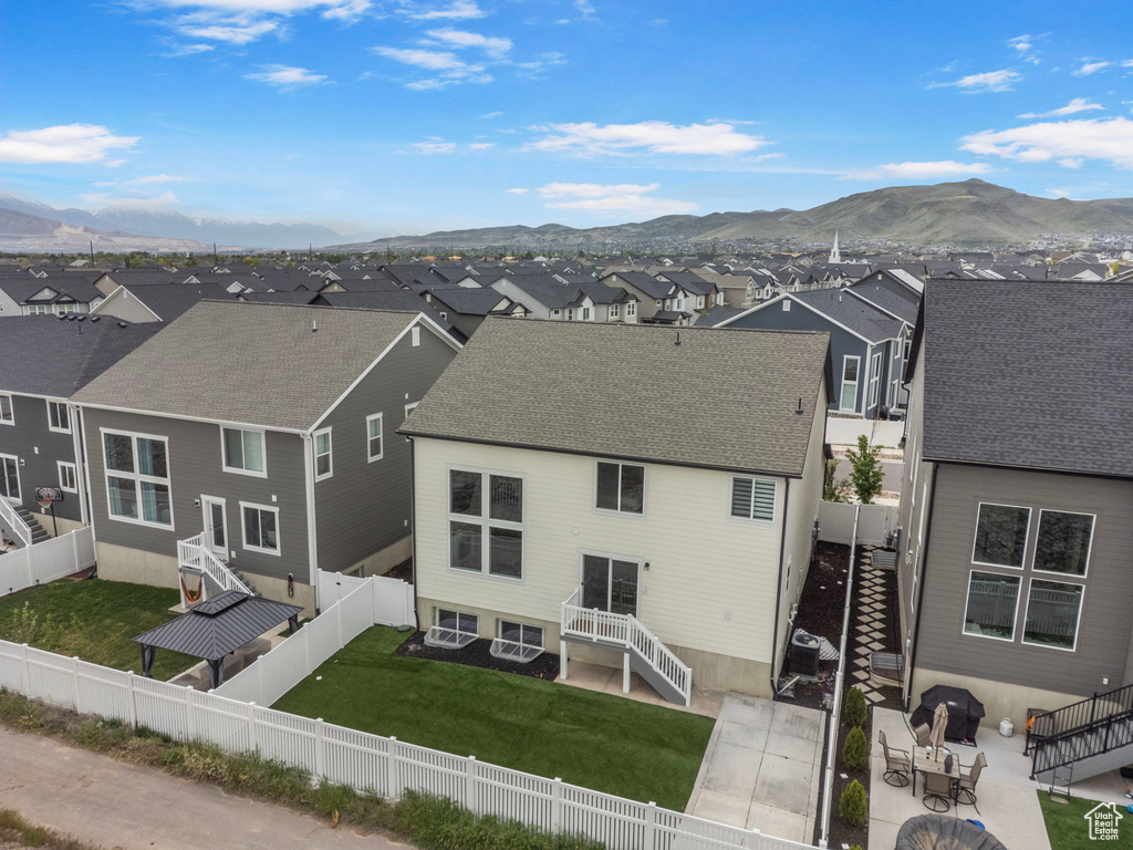 Rear view of property featuring a residential view, a mountain view, stairs, and a patio