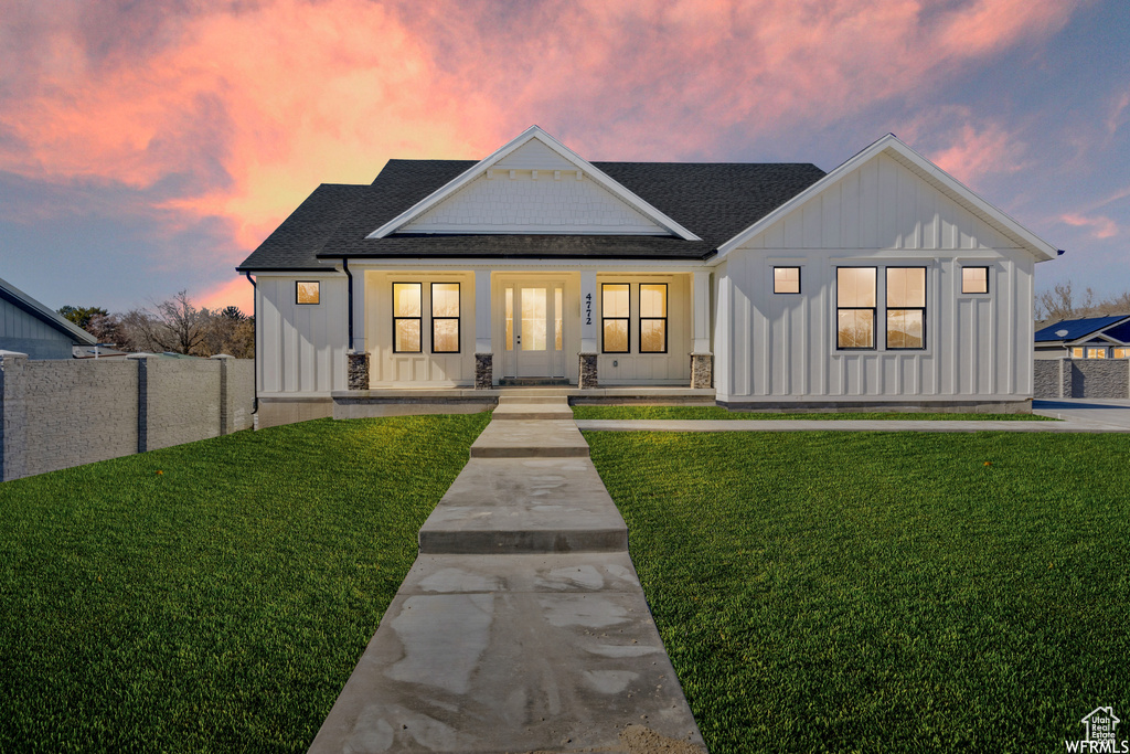 Modern farmhouse with board and batten siding, a porch, and a shingled roof