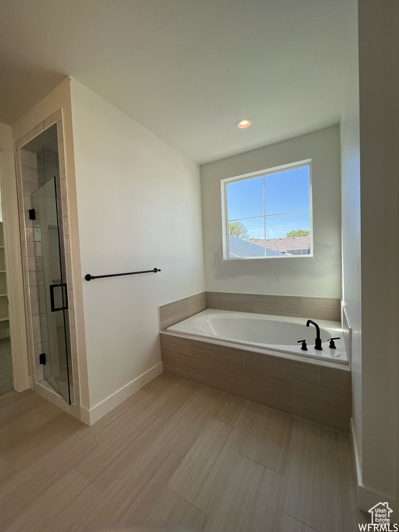 Full bathroom with a bath, a shower stall, recessed lighting, and baseboards