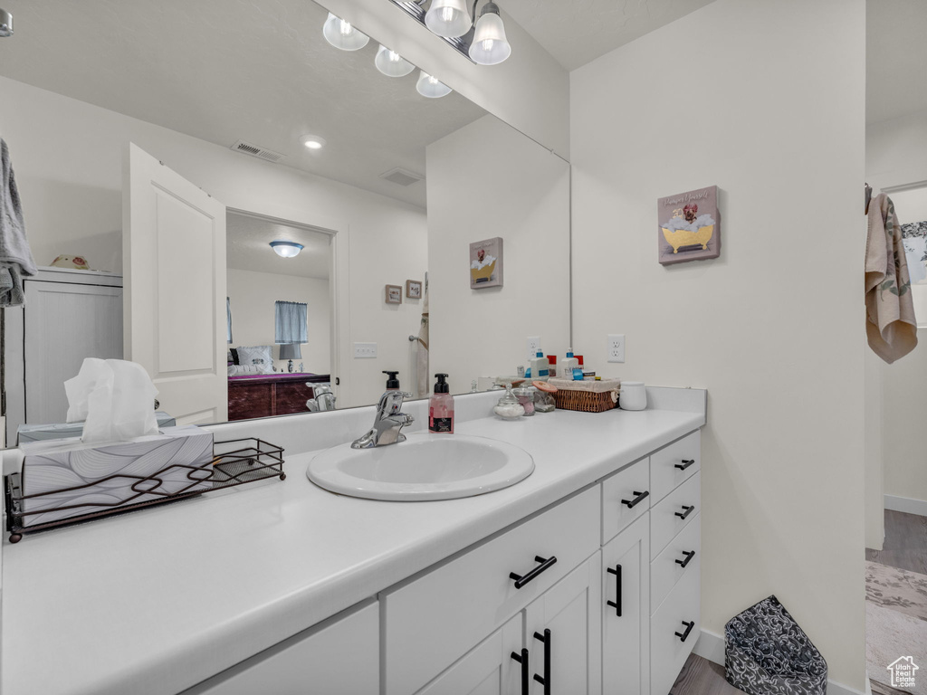 Bathroom with vanity, wood finished floors, and recessed lighting
