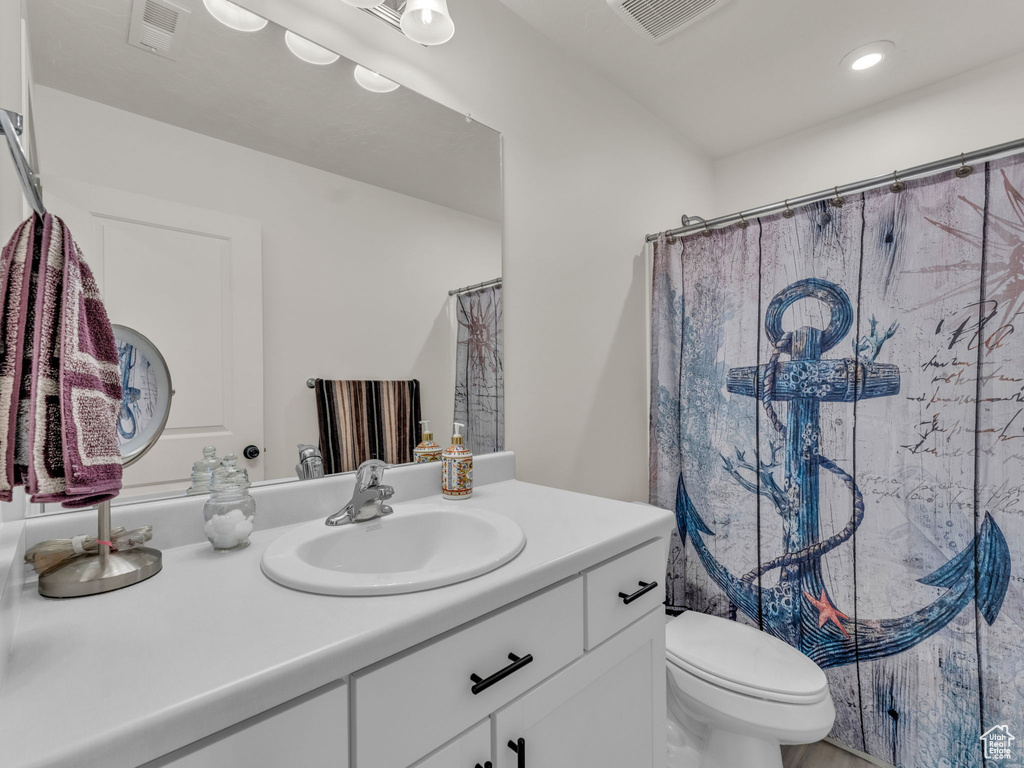 Bathroom with vanity, toilet, curtained shower, and recessed lighting