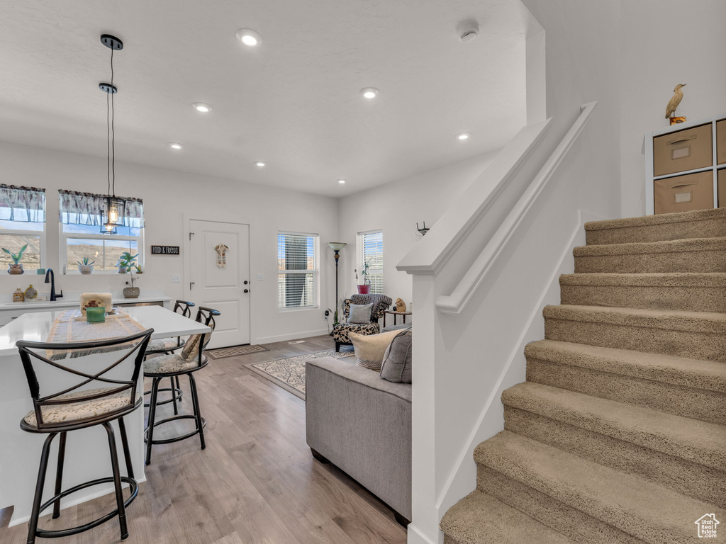 Living area with stairs, recessed lighting, and light wood-type flooring