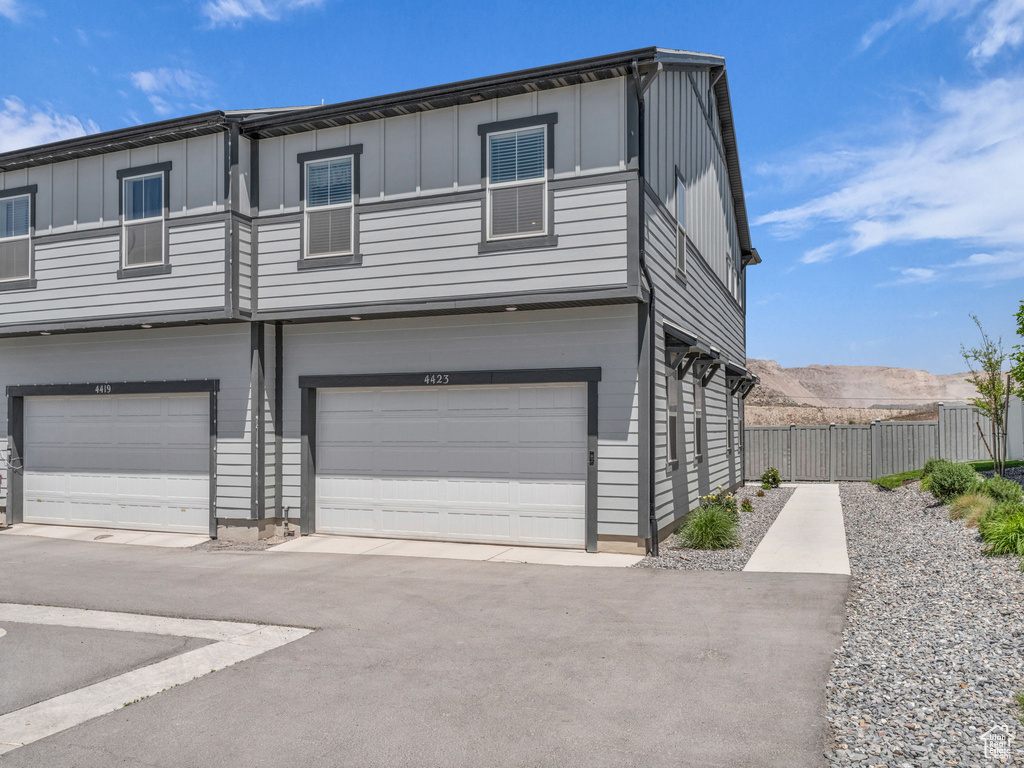 Townhome / multi-family property with an attached garage and board and batten siding