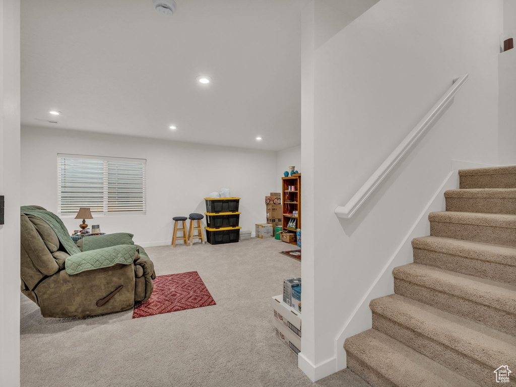 Carpeted living room with stairway, recessed lighting, and baseboards
