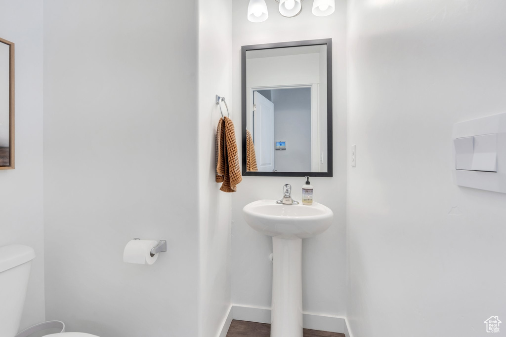 Bathroom featuring toilet, baseboards, and a sink