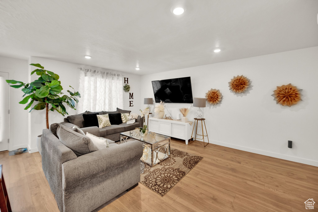 Living area with recessed lighting, light wood-style floors, and baseboards