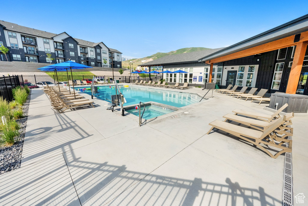 Community pool featuring a community hot tub, a patio area, and a mountain view