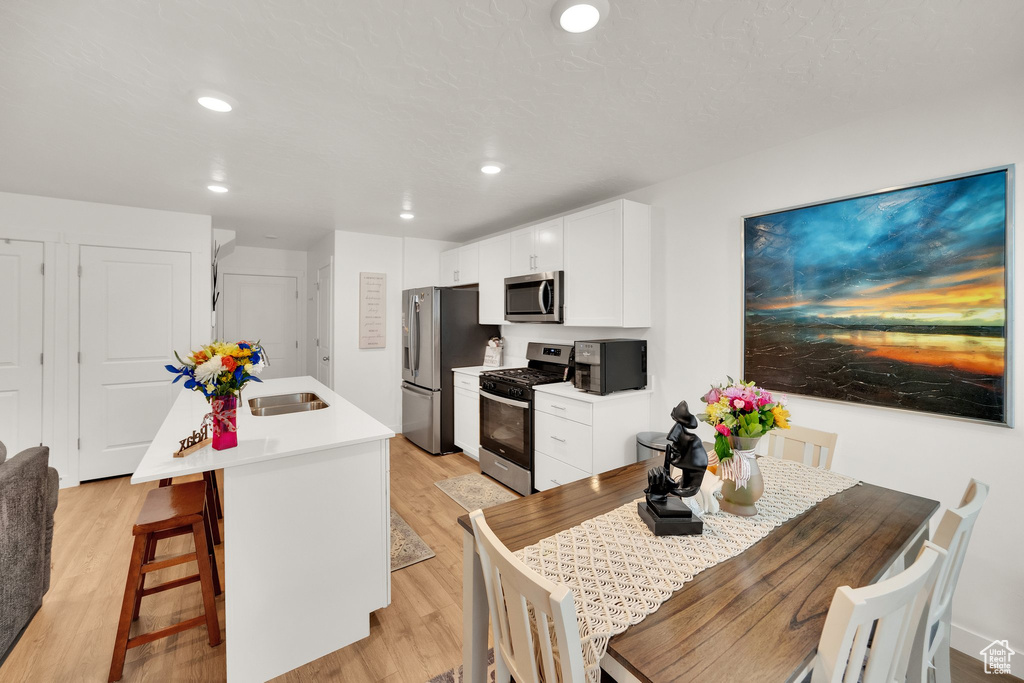 Dining space with light wood-type flooring and recessed lighting