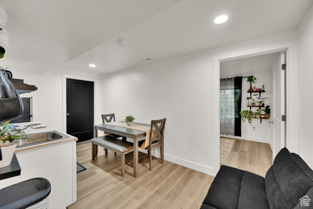 Dining space with light wood-style floors, recessed lighting, and baseboards