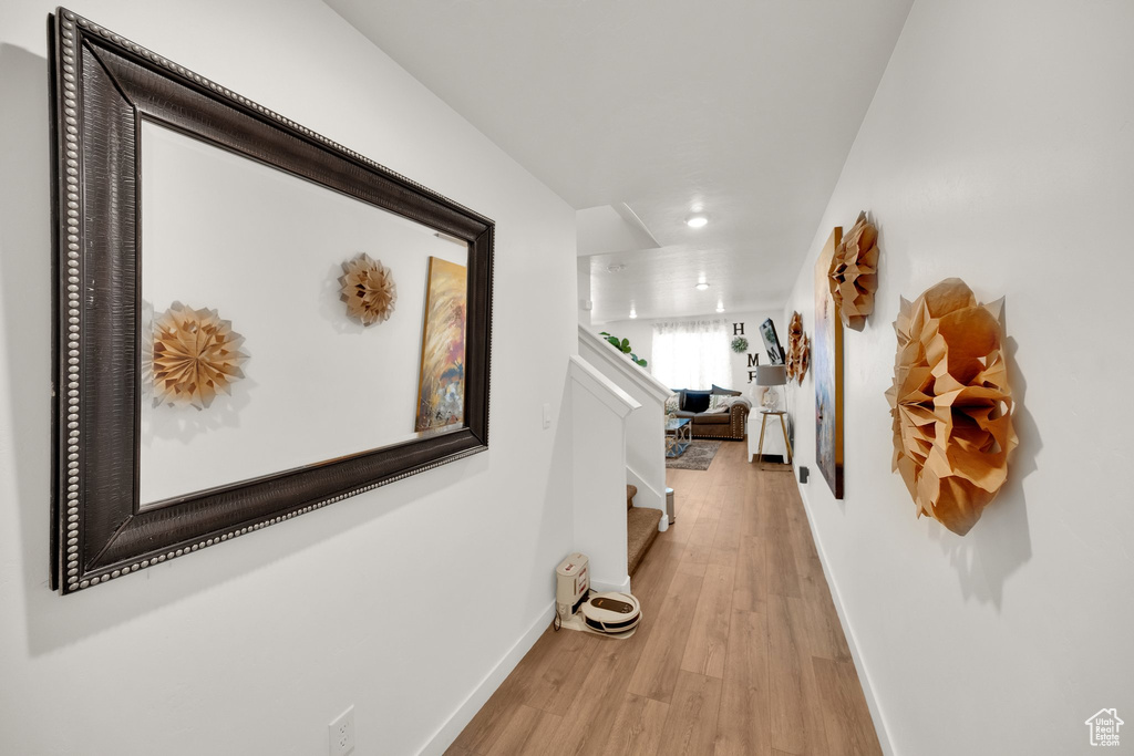 Corridor featuring light wood-type flooring, baseboards, and recessed lighting