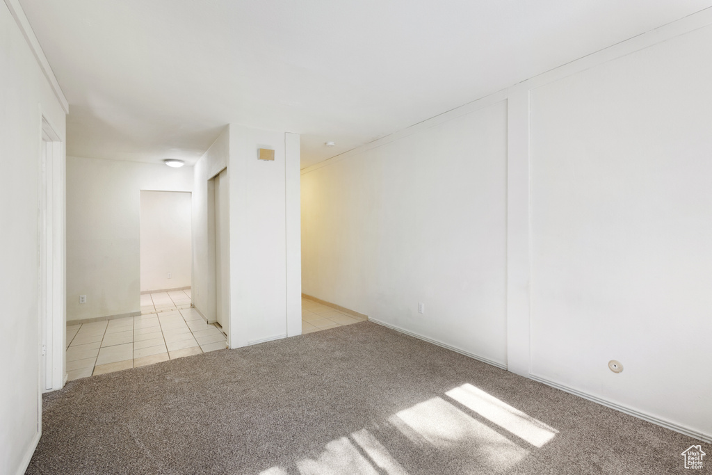 Carpeted empty room with tile patterned flooring