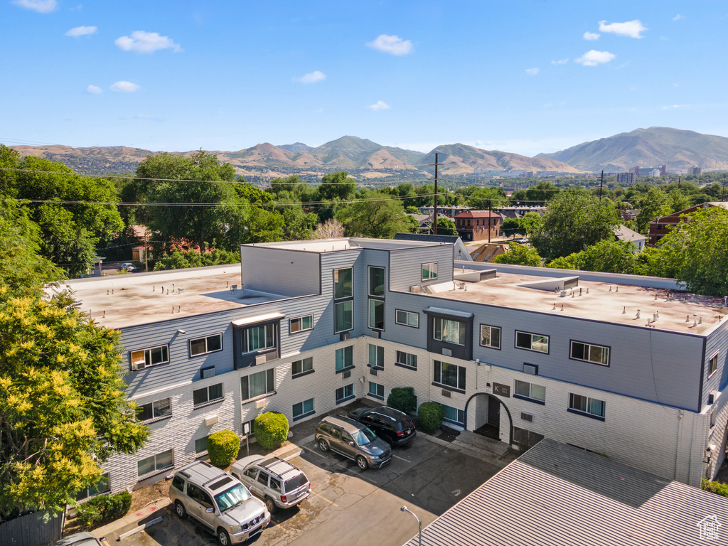 View of building exterior with uncovered parking and a mountain view
