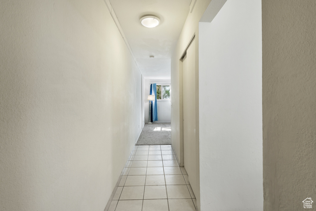 Corridor featuring light tile patterned floors