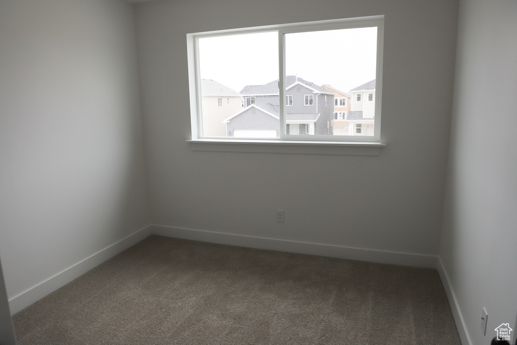 Carpeted empty room with baseboards