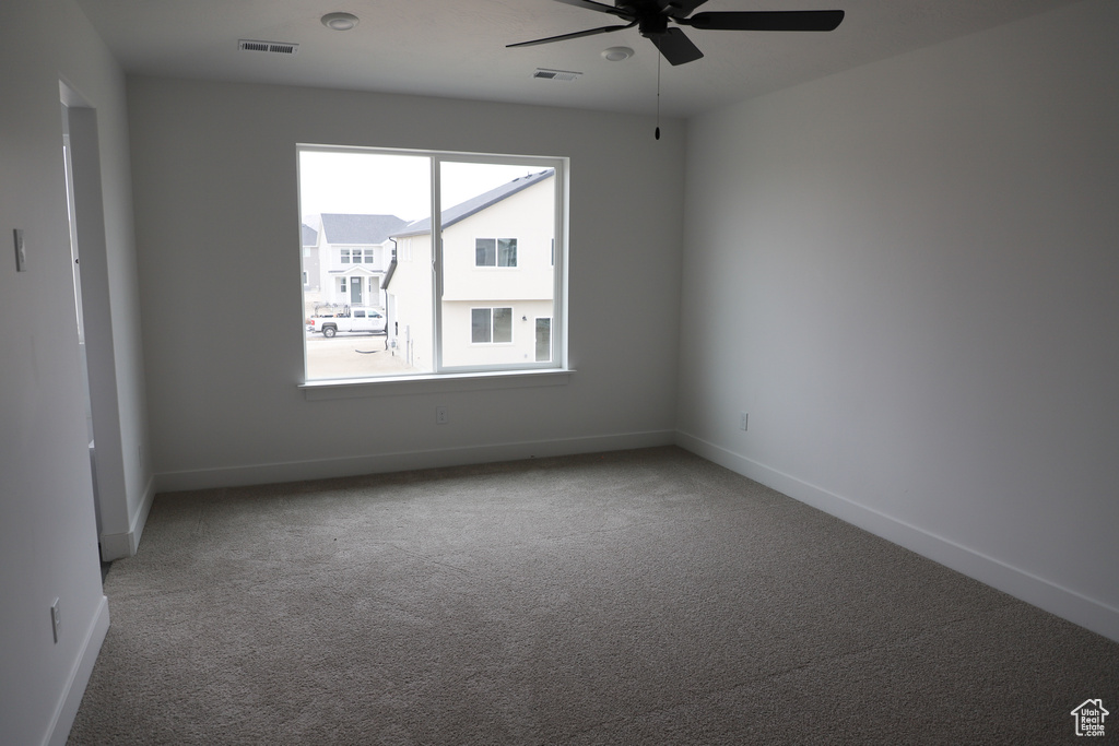 Unfurnished room with ceiling fan, carpet floors, and baseboards