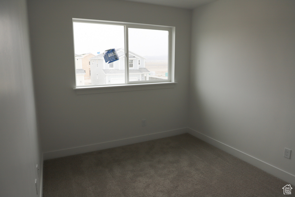 Carpeted empty room featuring baseboards