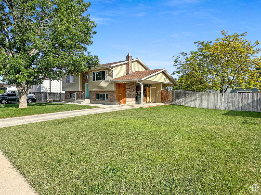 View of front of house featuring a chimney, brick siding, and concrete driveway