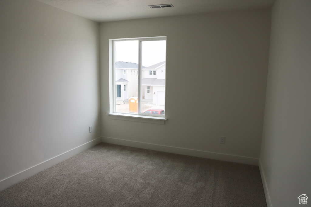 Carpeted empty room featuring baseboards