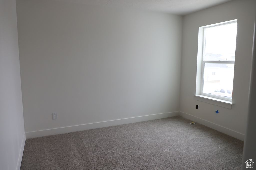 Spare room featuring carpet and baseboards