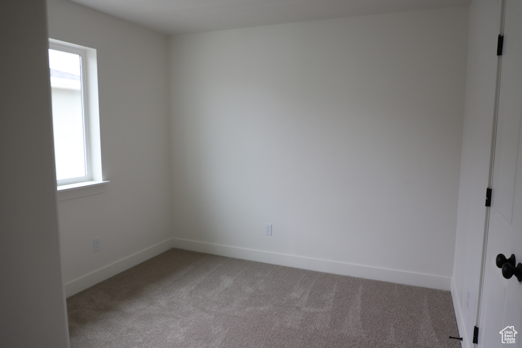 Unfurnished room with light colored carpet and baseboards